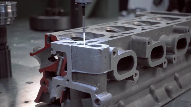 The probe of the coordinate measuring machine (CMM) touch to the internal combustion engine head under researching and introduces data to the computer. Shot in motion
