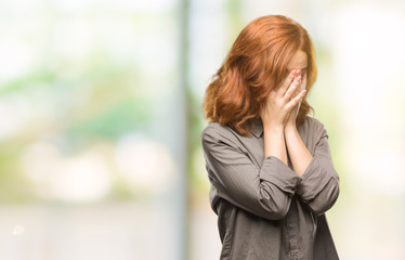 Young beautiful woman over isolated background with sad expression covering face with hands while crying. Depression concept.