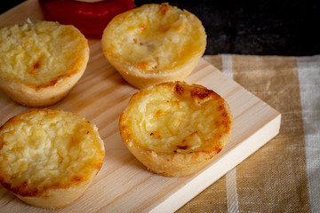Homemade mini quiche with cheese on rustic background.