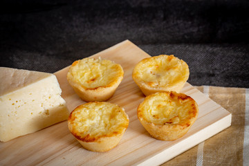 Homemade mini quiche with cheese on rustic background.