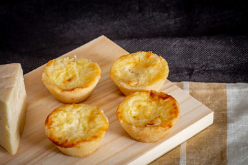 Homemade mini quiche with cheese on rustic background.