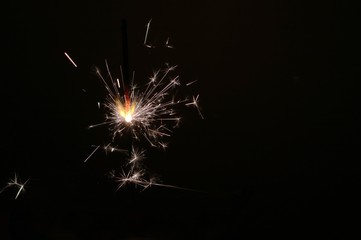 Sparkler on a dark background as a symbol of the New year holiday.