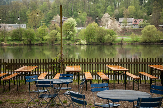 Verlassener Biergarten mit nassen Biertischen am Main in Marktheidenfeld