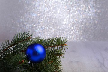 Fototapeta na wymiar Decorative background with fir branches and blue balls on the silver. Christmas card Holiday Concept
