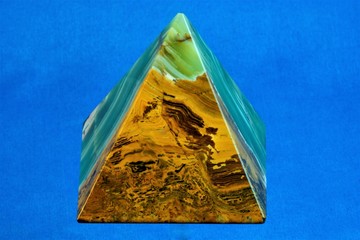 Pyramid of onyx stone on a blue background, architectural structure, a symbol of hierarchy existing...