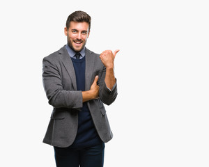 Young handsome business man over isolated background smiling with happy face looking and pointing to the side with thumb up.