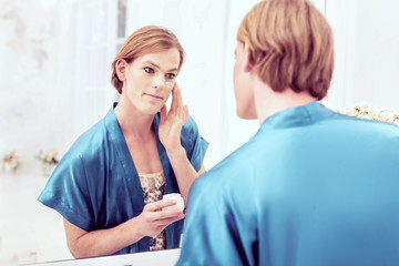 Obraz premium Portrait of transgender woman putting on makeup in mirror
