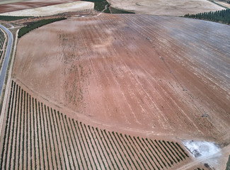 Aerial view of textures. Rows of soil with plantations. Pattern rows of furrows in a plowed field...