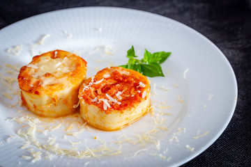 Italian rondelli with pomodoro sauce and cheese on rustic background.