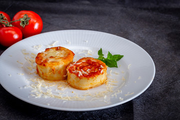 Italian rondelli with pomodoro sauce and cheese on rustic background.