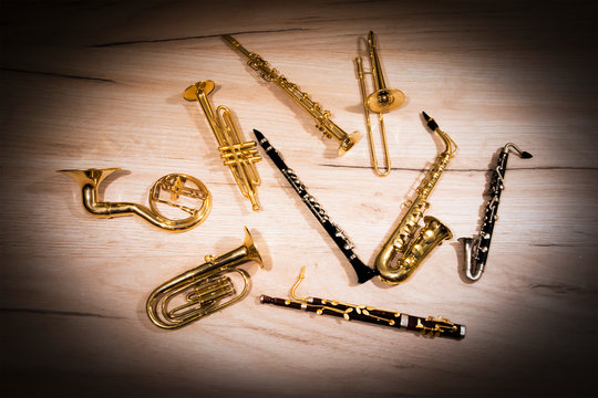 A number of toy wind instruments  lying on a wooden board, dark vignette