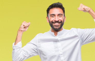 Fototapeta premium Adult hispanic man over isolated background showing arms muscles smiling proud. Fitness concept.
