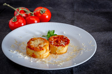 Italian rondelli with pomodoro sauce and cheese on rustic background.