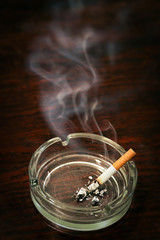 Cigarette in ashtray, smoke