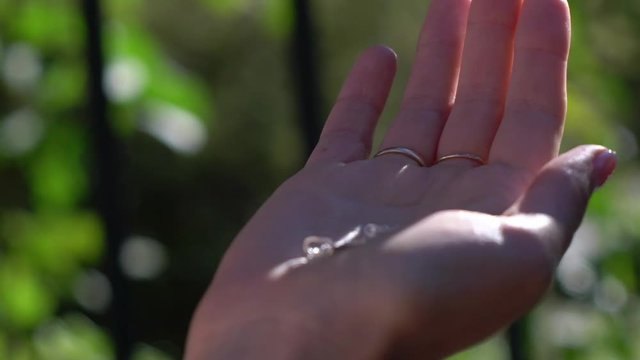 Young beautiful woman holding silver cross in hands. Christianity religion. God in hands.