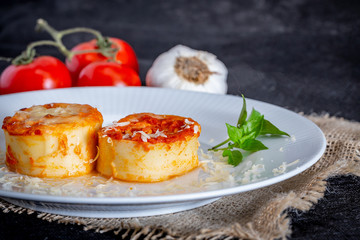 Italian rondelli with pomodoro sauce and cheese on rustic background.