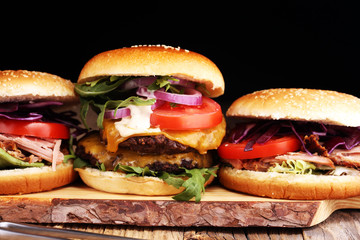 Tasty fresh meat burgers with salad and cheese. Homemade angus burger and Pulled pork sandwiches.