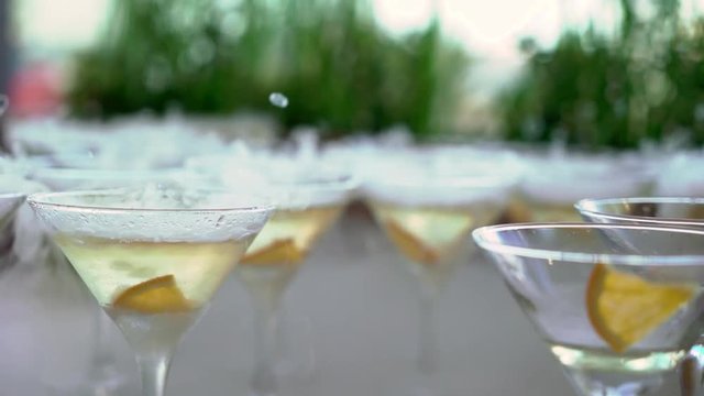 Glasses of sparkling wine with dry ice at the party. Slowmotion closeup.
