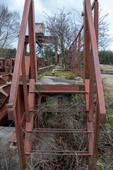 Fototapeta na wymiar old red metal bridge over water