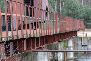 Fototapeta na wymiar old red metal bridge over water