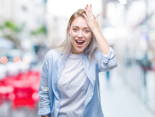 Young blonde woman over isolated background surprised with hand on head for mistake, remember error. Forgot, bad memory concept.