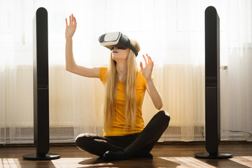 Girl wearing virtual reality goggles at home