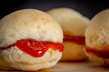 Brazilian homemade cheese bread AKA 'pao de queijo’, stuffed with guava dessert, on a rustic background.