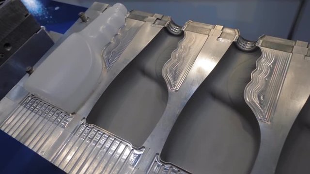 Molds of the extrusion equipment for manufacture of plastic bottles for storing liquid products and cleaning products. Shot in motion