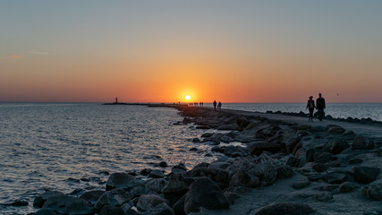 breakwater in the sea with red lighthouse at the end