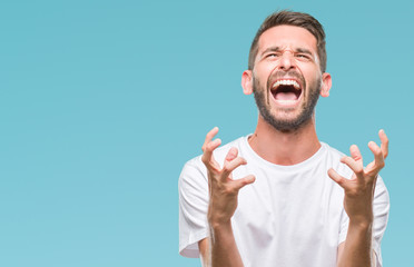 Young handsome man over isolated background crazy and mad shouting and yelling with aggressive...