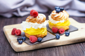 Cake with biscuit and berries and sprinkle on a substrate on a colored background.