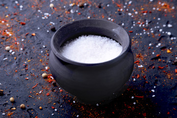 Red spices, salt and pepper on black marble. Black abstract background. Top view.