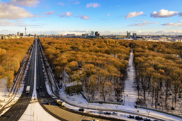 Aerial panoramic view of cityscape of Berlin skyline and scenery of trees without leaves in winter season at Tiergarten park from above at Victory Column with background of dusk sunset sky in Berlin.