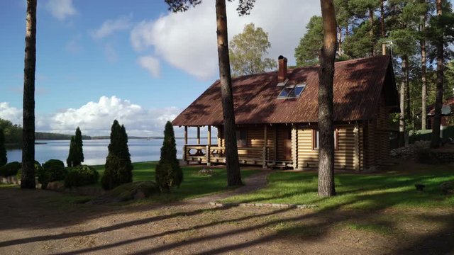 A wooden cottage near lake or sea. Luxury house for vacations. Summer day