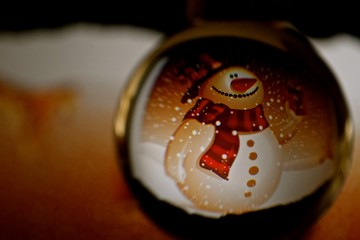 Taken through glass ball distorting the images. Christmas scenes of stars, snowman and star Christmas trees.