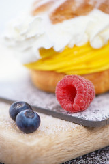 Cake with biscuit and berries and sprinkle on a substrate on a colored background.