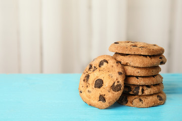 Stack of tasty chocolate chip cookies on wooden table. Space for text