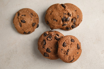 Tasty chocolate chip cookies on light background, top view
