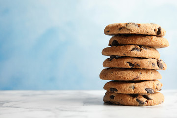 Stack of tasty chocolate chip cookies on table. Space for text