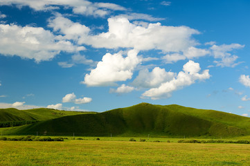 Fototapeta na wymiar The beautiful cloudscape and rainbow on the grassland.