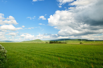 The beautiful cloudscape and rainbow on the grassland.