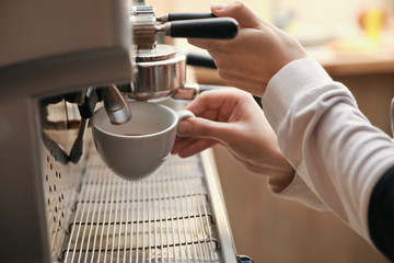 Barista preparing coffee using modern machine, closeup