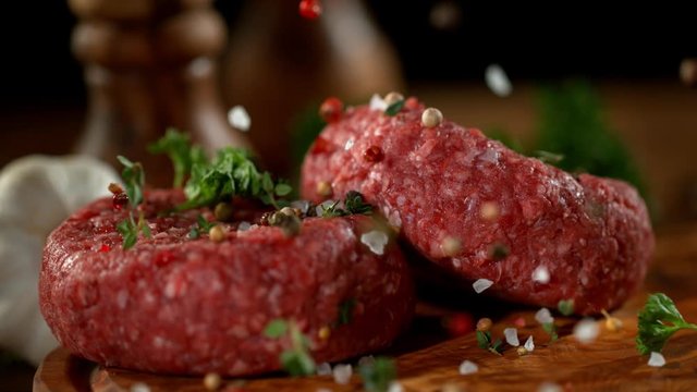 Super slow motion of falling spices on beef minced hamburger meats, filmed on high speed cinema camera, 1000 fps.