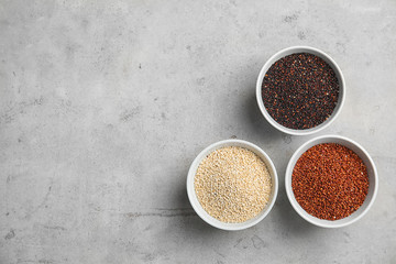 Flat lay composition with different types of quinoa and space for text on grey background