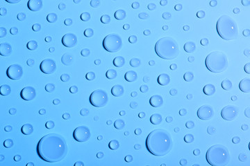 Water drops on color background, top view