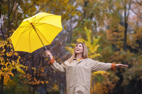 Woman with umbrella in autumn park on rainy day