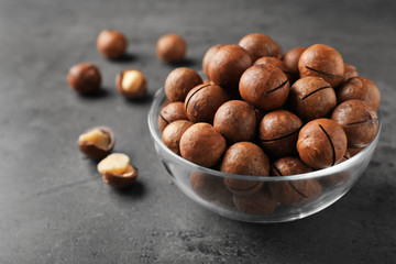 Bowl with organic Macadamia nuts and space for text on grey background
