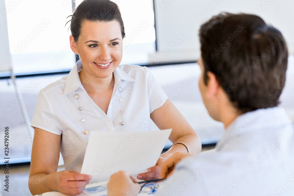 Wall mural Image of two young business people in office