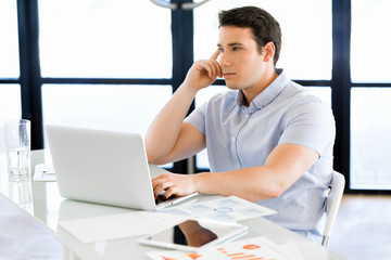 Obraz premium Handsome businessman working at computer