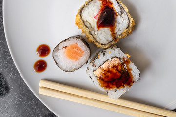 Uramaki and Hot Roll on a plate with chopsticks